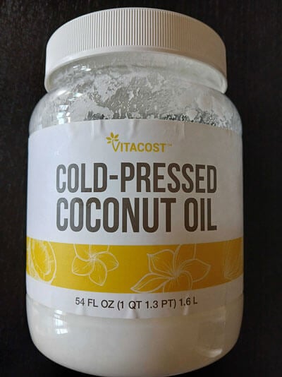 Yellow Vitacost logo on white label on coconut oil.