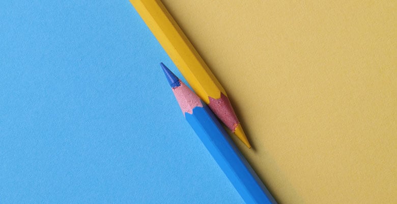 Blue and yellow pencils angled against backgrounds of the same colors.